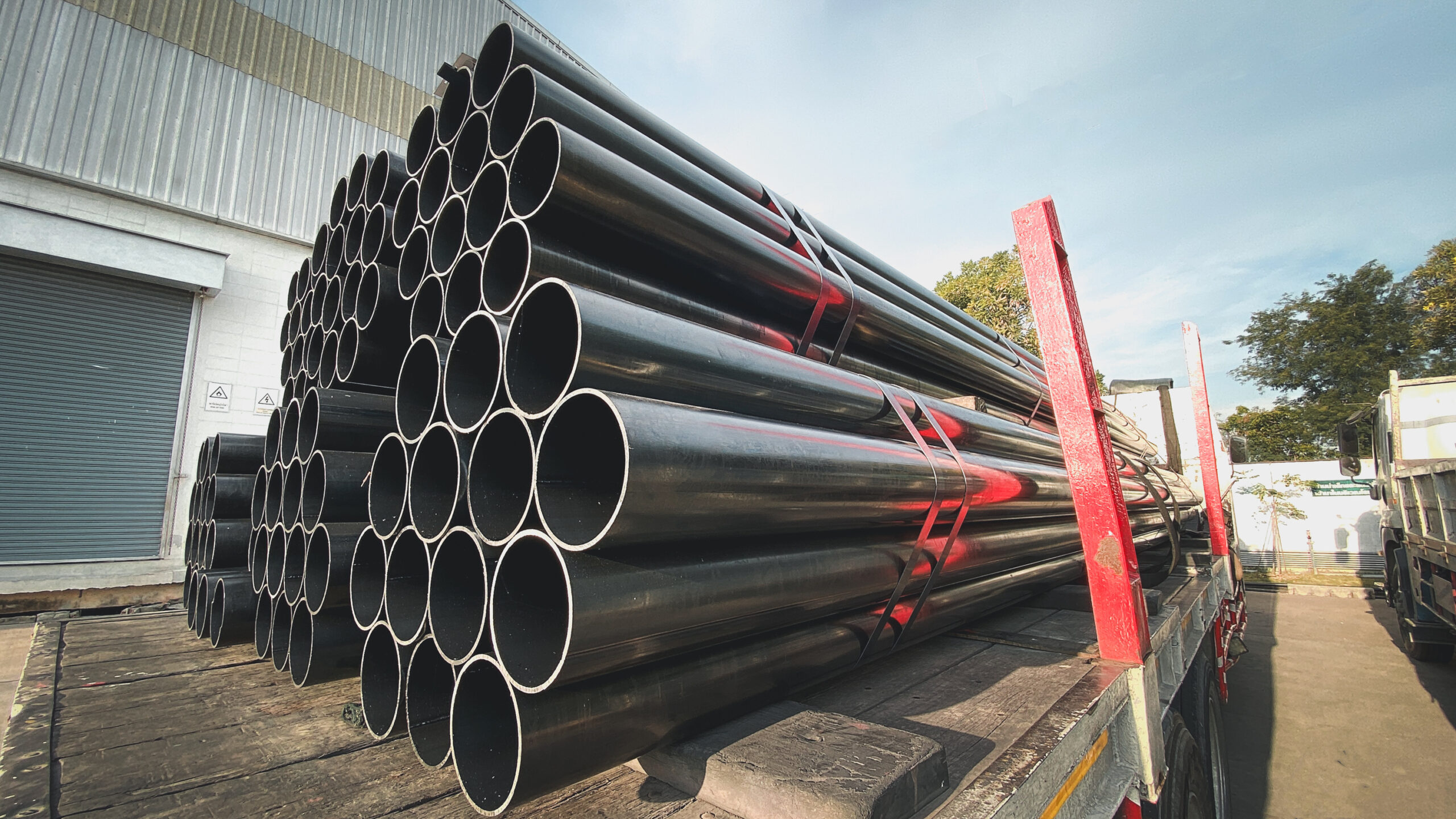 Construction products on transport vehicles Group of steel pipes for industrial materials Construction engineering products  equipment, steel pipes, metal warehouse industry, delivery to customers
